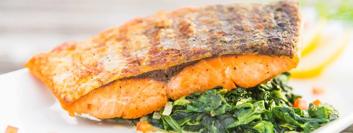 Grilled salmon fillet fish steak with lemon on white plate
