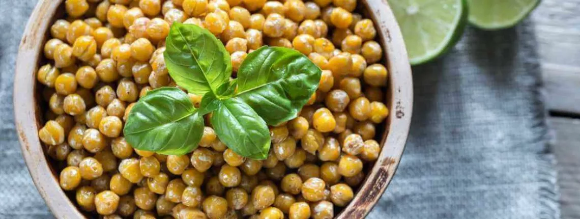 Bowl of roasted chickpeas on the wooden background