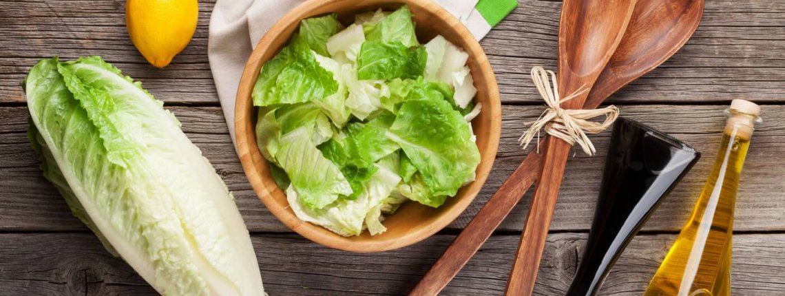 Fresh healthy romaine lettuce salad on wooden table. Top view