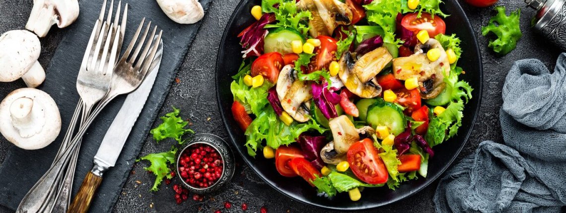 Salad with fresh and grilled vegetables and mushrooms. Vegetable salad with grilled champignons. Vegetable salad on plate. Healthy vegetarian food